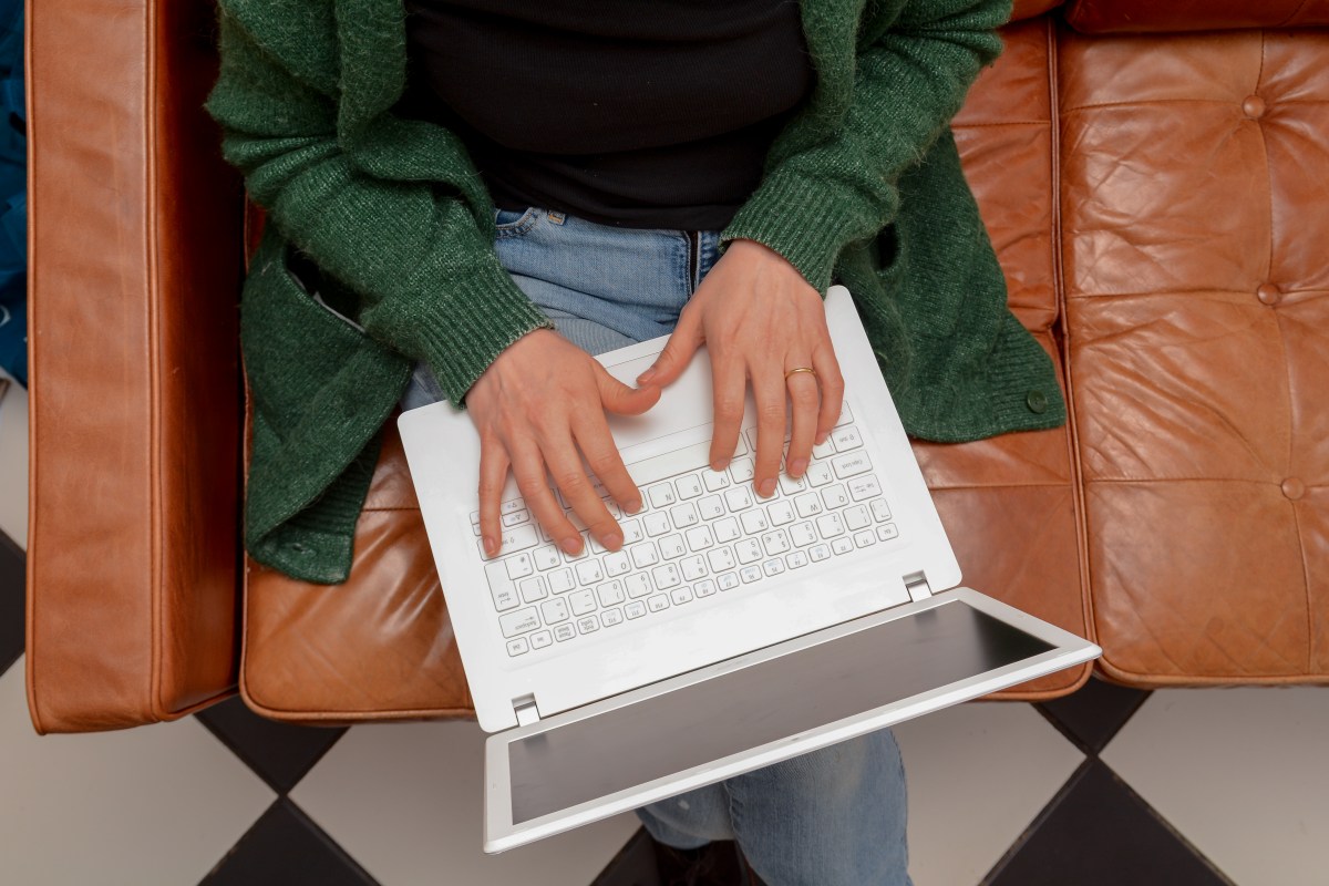 Frau zu Hause mit Laptop-Computer auf der Couch.