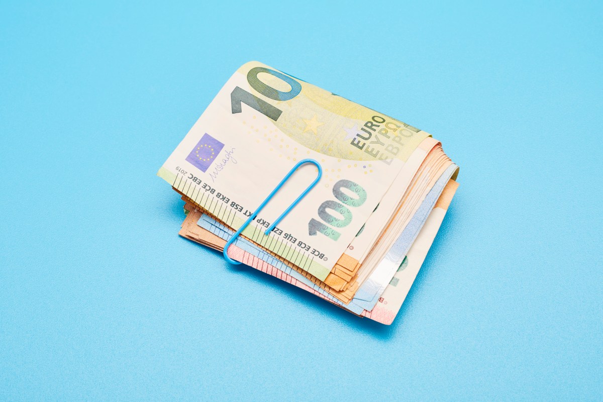 Stillleben mit einem Bündel Euro-Banknoten auf blauem Hintergrund.