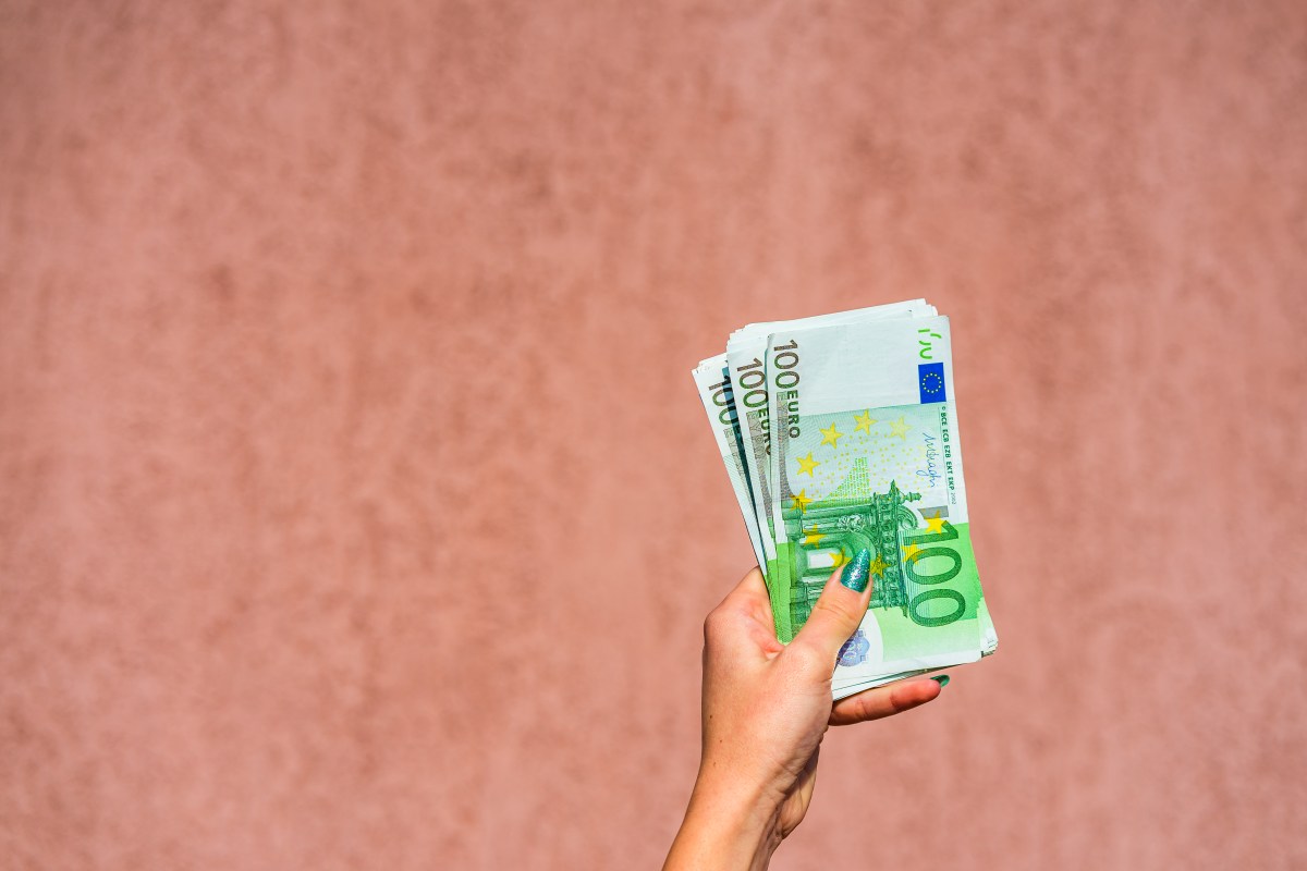 Hand, die Euro-Scheine hält.