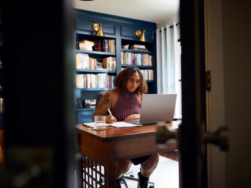 Eine Frau arbeitet in ihrem Home-Office an einem Laptop.