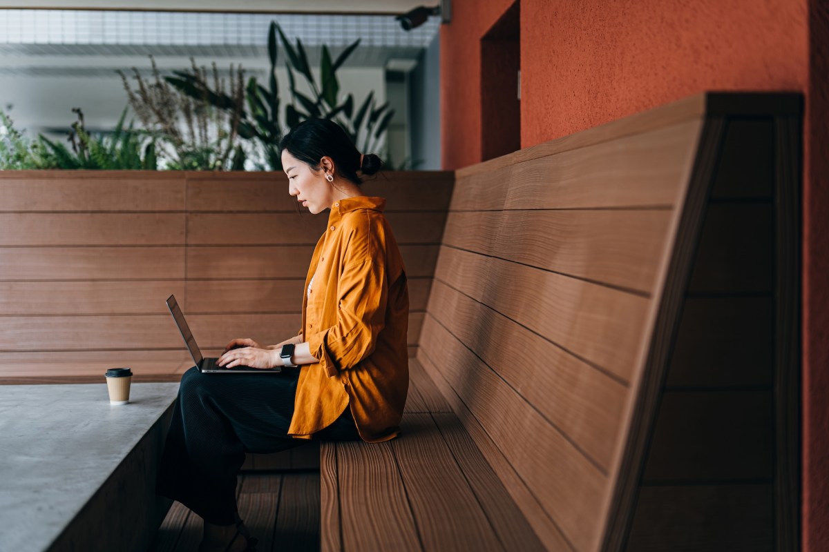 Junge Frau sitzt vor ihrem Laptop.