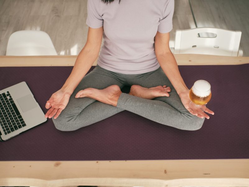 Frau macht Yoga mit Bier