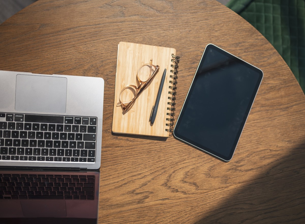 Übersicht über ein Tablet mit leerem Bildschirm und einen Laptop auf einem Schreibtisch.