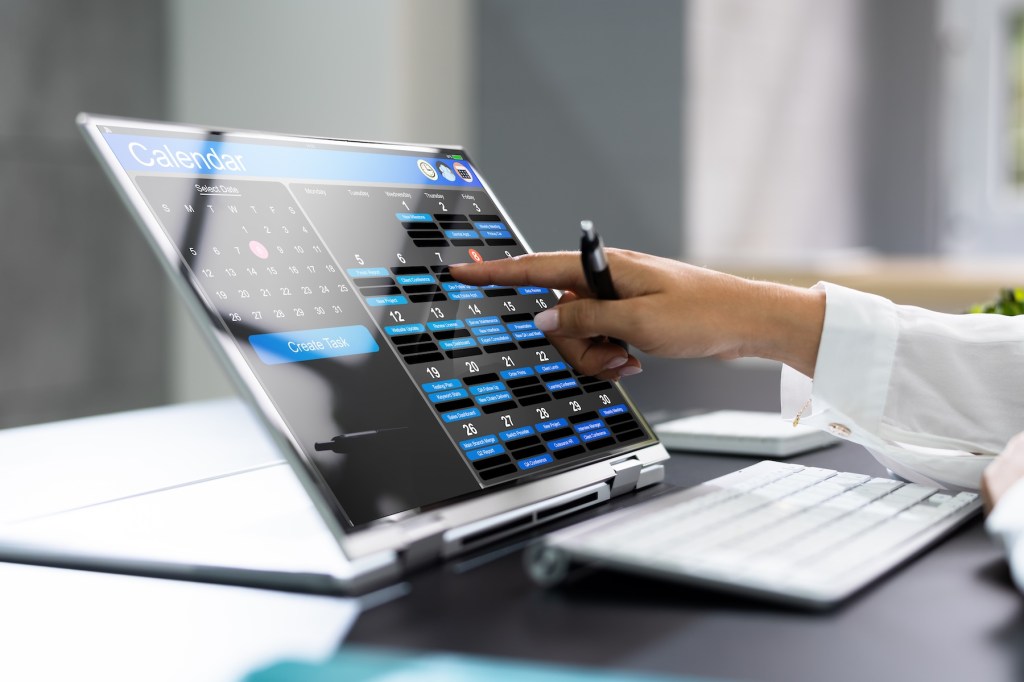 Eine Frau trägt einen Termin in ihrem Online-Kalender ein.