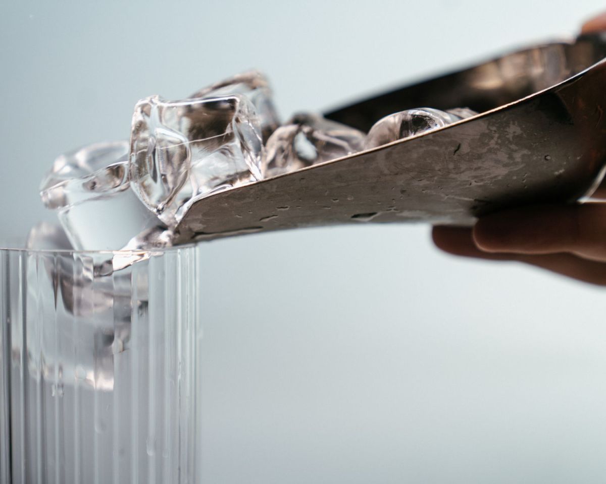 Hand macht Eis in ein Glas
