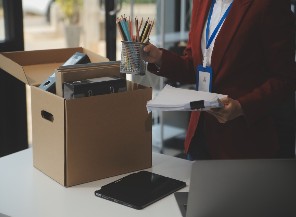 Geschäftsfrau packt ihre Sachen in einen Karton.