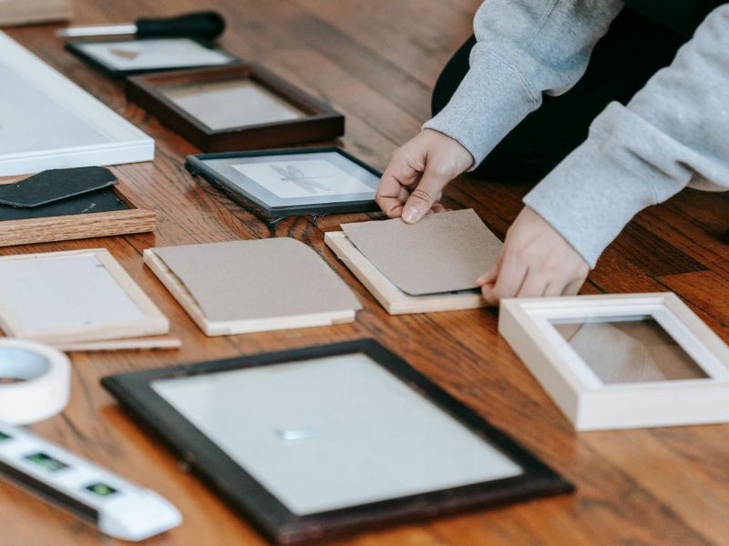 Frau rahmt Bilder in Bilderrahmen ein