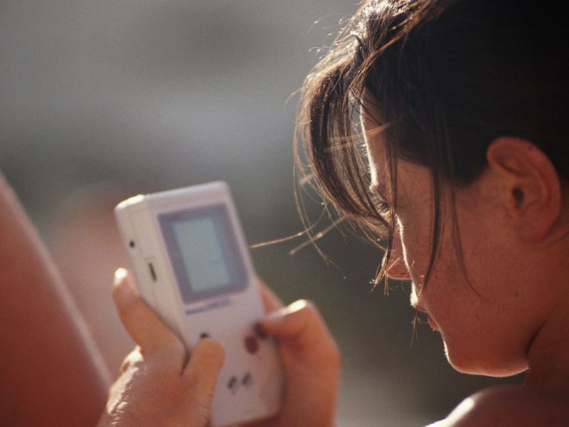 Frau spielt auf dem Gameboy