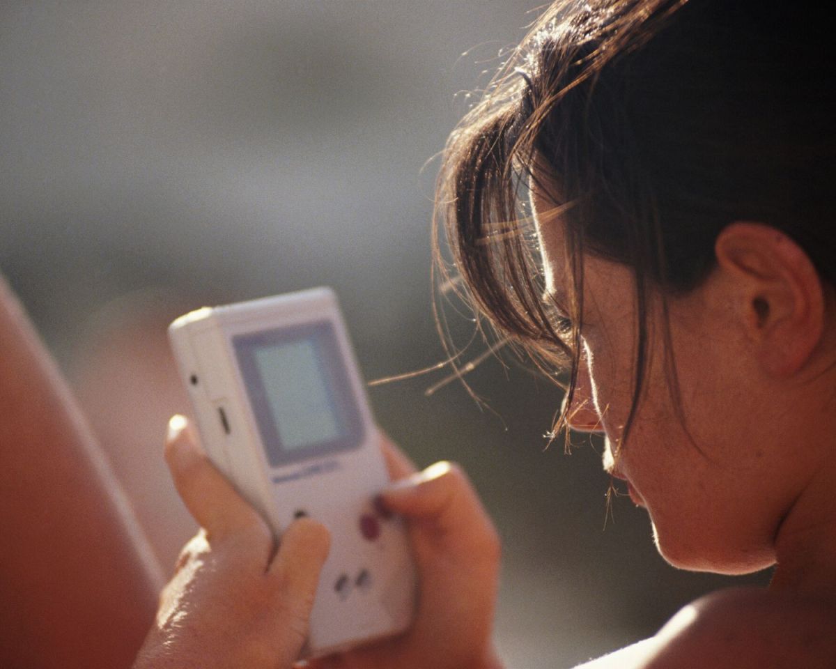 Frau spielt auf dem Gameboy