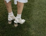 Frau mit Absatzschuhen auf grünem Rasen