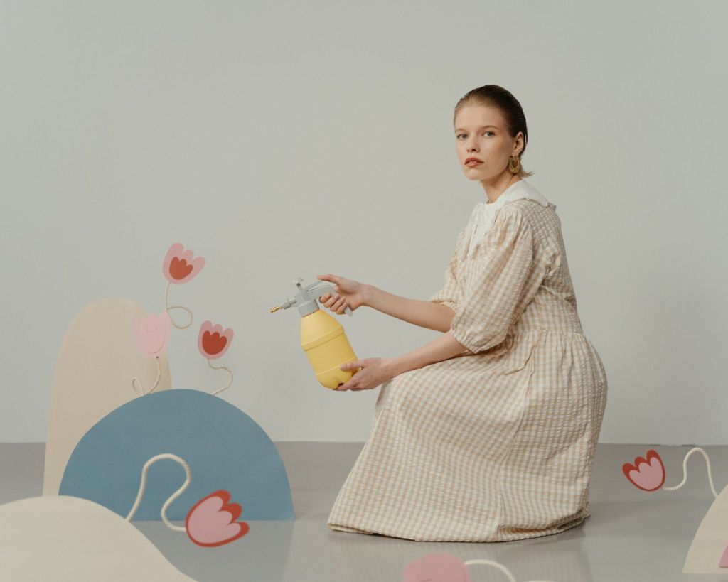 Frau gießt Plastik-Blumen