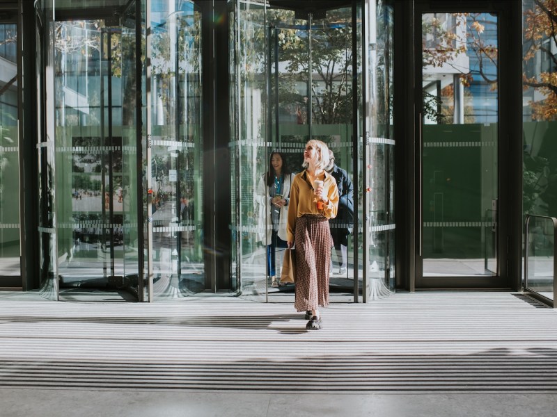Eine Frau verlässt ein Bürogebäude.