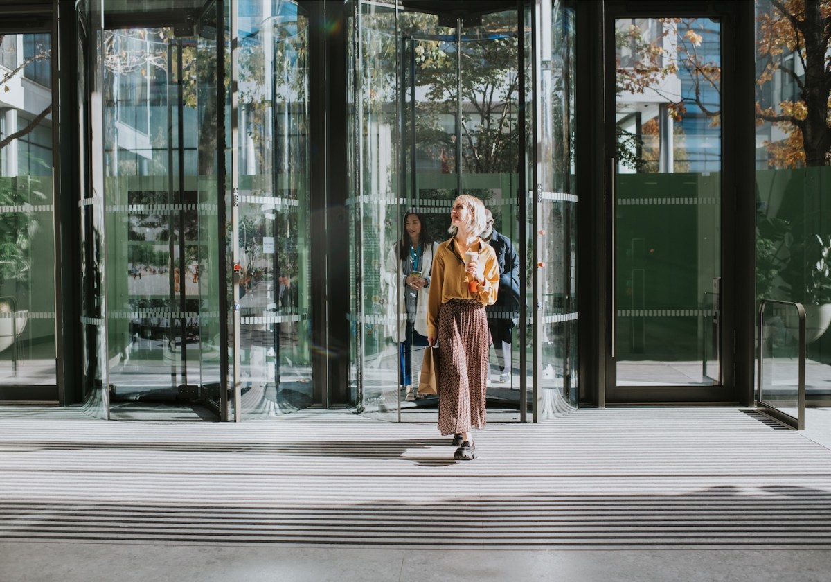 Eine Frau verlässt ein Bürogebäude.