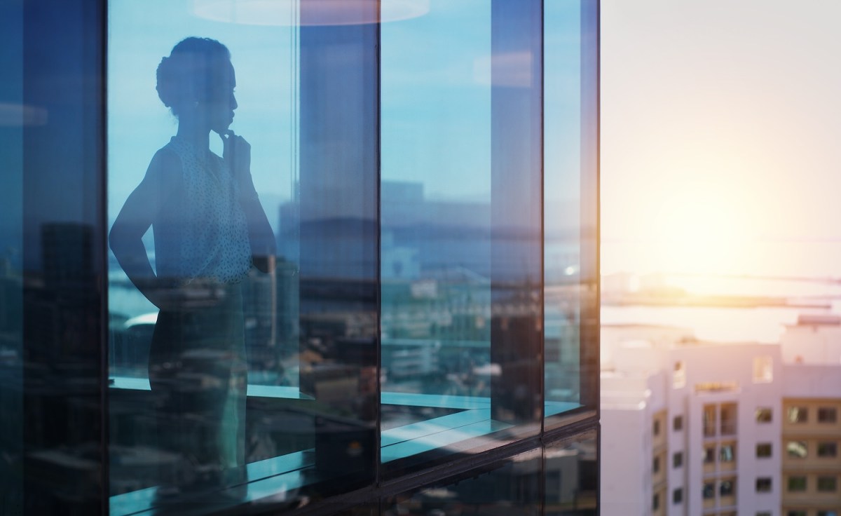 Aufnahme einer Geschäftsfrau, die nachdenklich aussieht, während sie aus dem Fenster schaut.