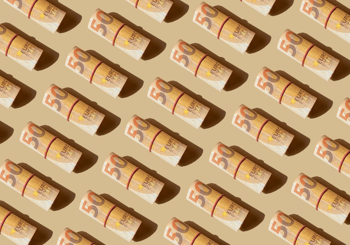Viele 50-Euro-schein-Rollen auf beigen Hintergrund.