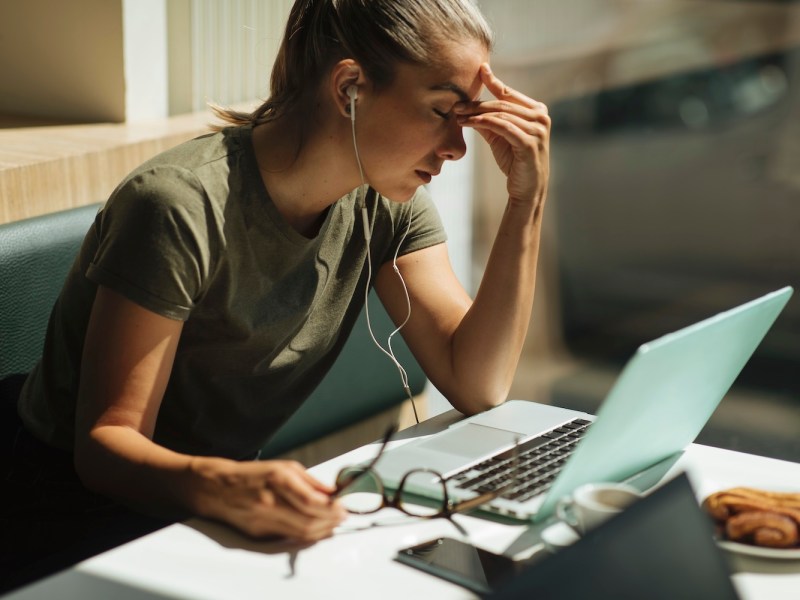 Aufnahme einer jungen Frau, die während ihres Arbeitstages unter Müdigkeit leidet.