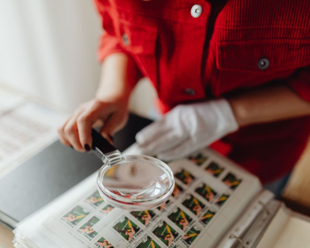 Frau untersucht Briefmarkensammlung.