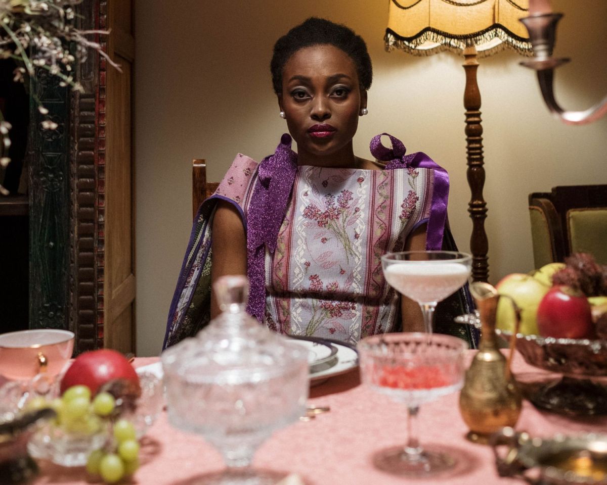 Frau sitzt an einem Tisch mit Kristallgläsern.