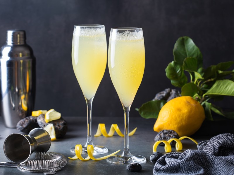 French 75 Cocktail steht angerichtet auf einem Tisch.