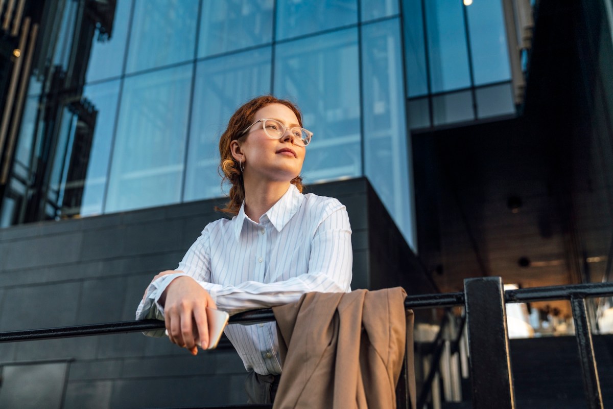 Nachdenkliche Geschäftsfrau stützte sich auf Geländer.