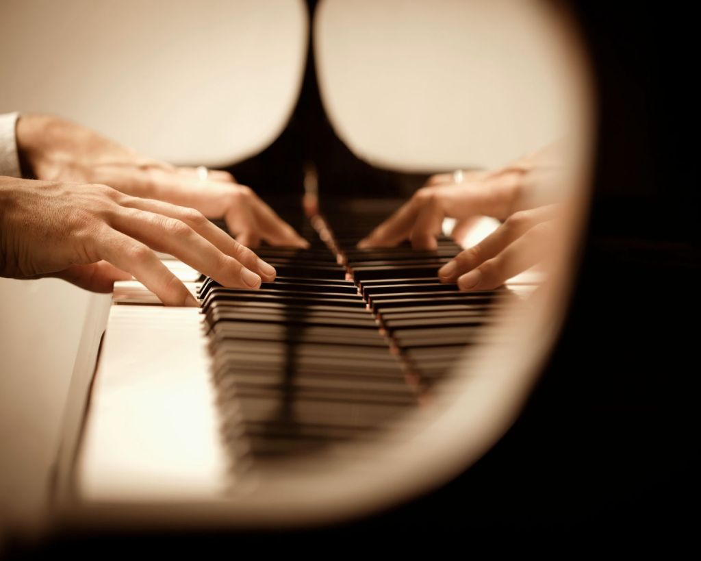 Hände auf Klaviertastaturen