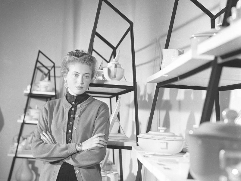 Frau steht vor einem Mid-Century Modern Regal