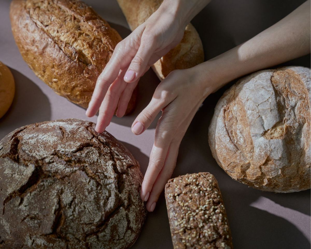 Hände greifen nach Brot
