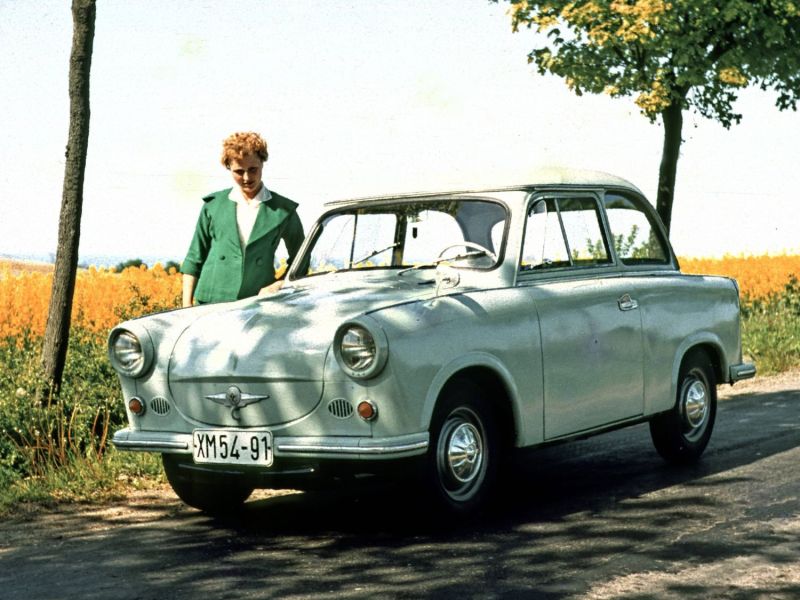 Frau steht neben einem Wartburger-DDR-Oldtimer.