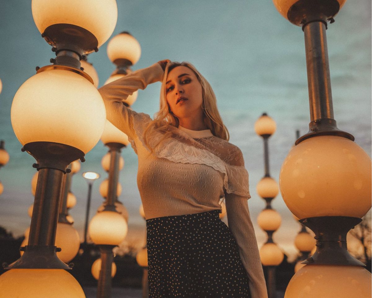 Frau steht zwischen Lampen