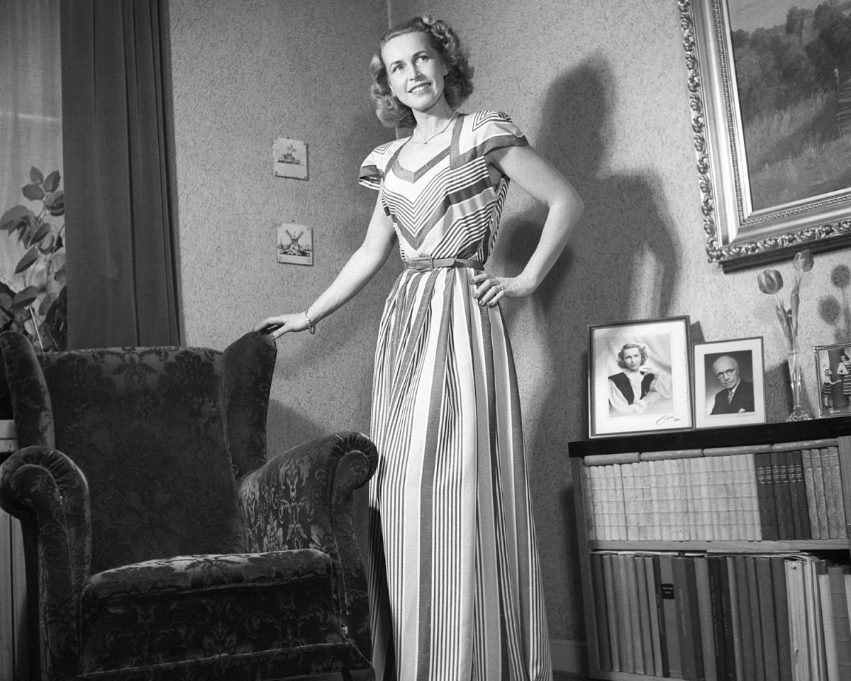 Frau steht neben einem Ohrensessel