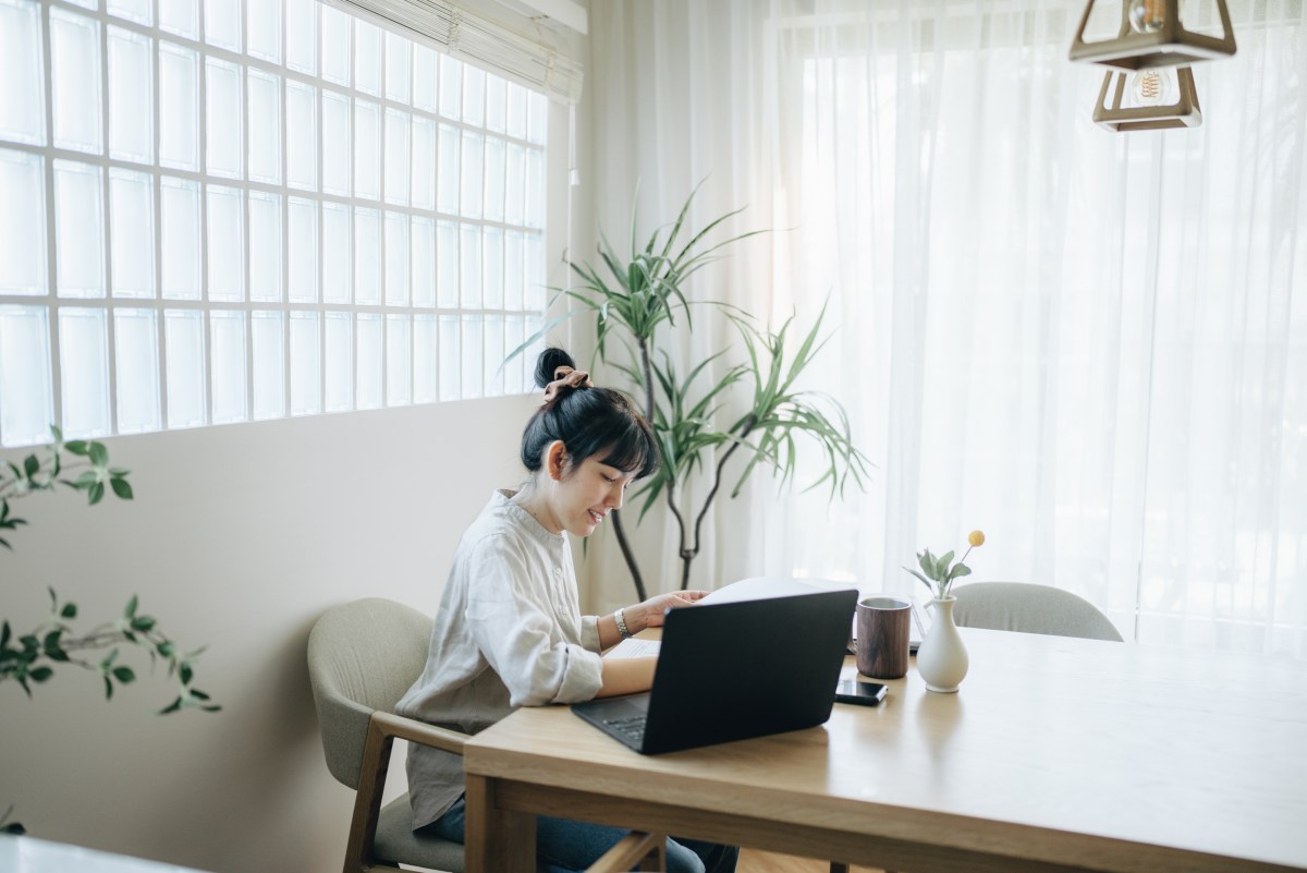 Frau arbeitet zu Hause am Laptop.