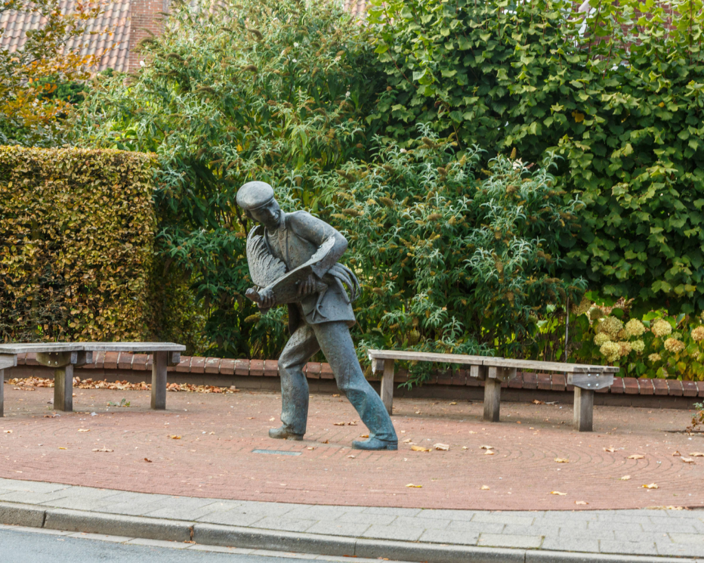 Bronzefiguren von Schmuggler*innen und Zöllner*innen erinnern auf dem Dorfplatz an frühere Zeiten.