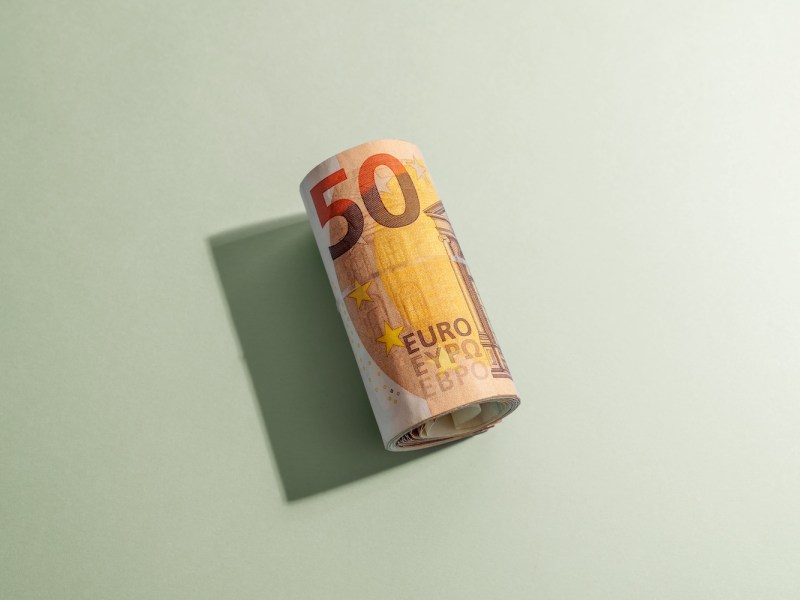 Fünfzig-Euro-Scheine auf orange-grünem Hintergrund.