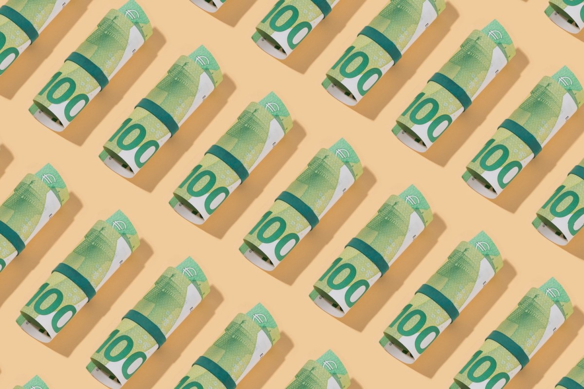 Rolle von Hundert-Euro-Scheinen auf beigen Hintergrund.