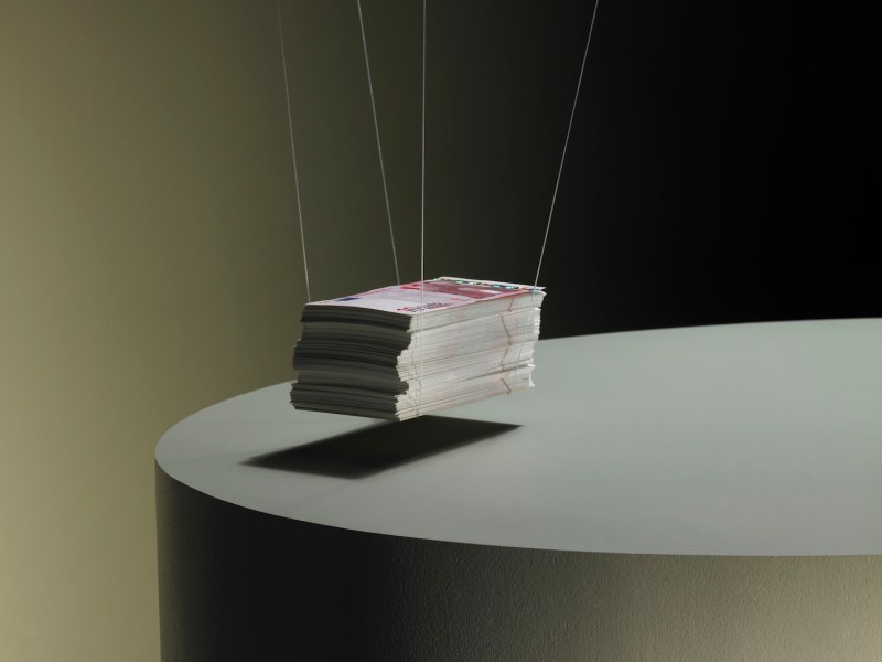 Geld hängt an einem Stapel in der Luft.