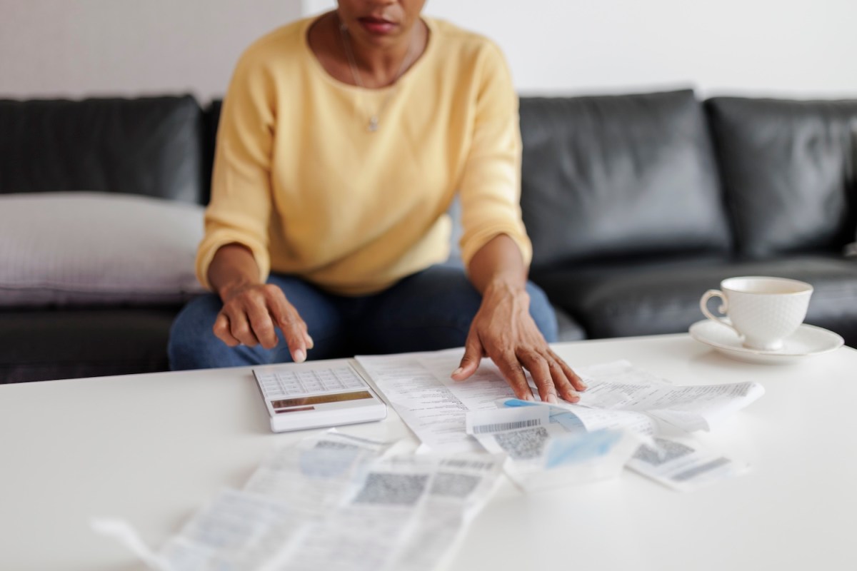 Frau, die im Wohnzimmer sitzt und ihre Steuerunterlagen prüft.