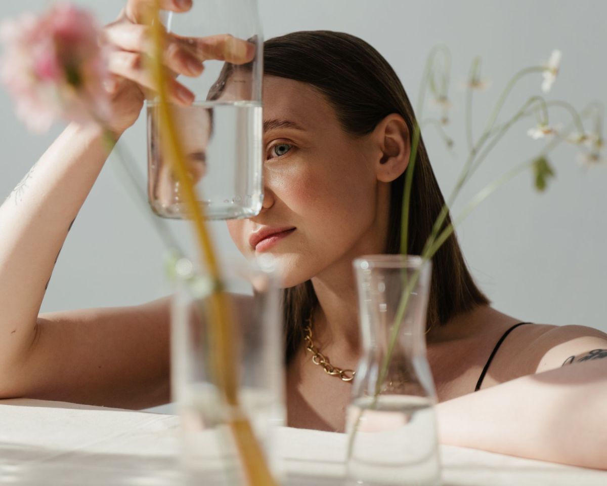 Frau schaut durch eine Blumenvase