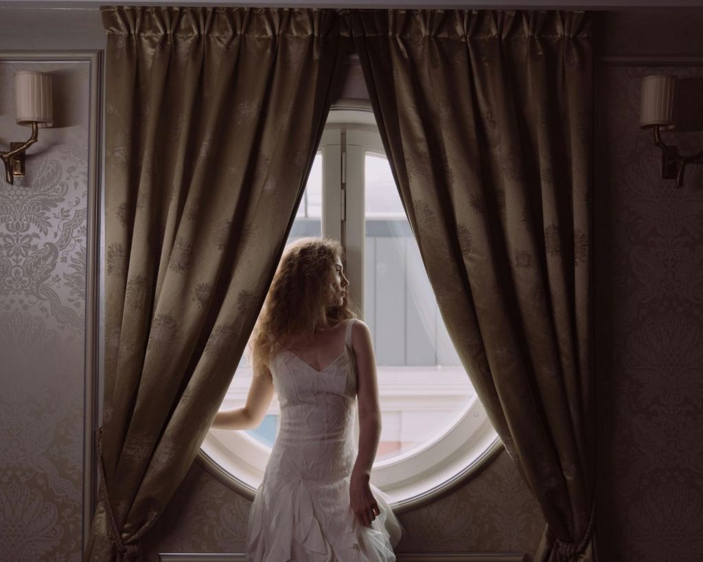 Frau steht vor einem Vorhang