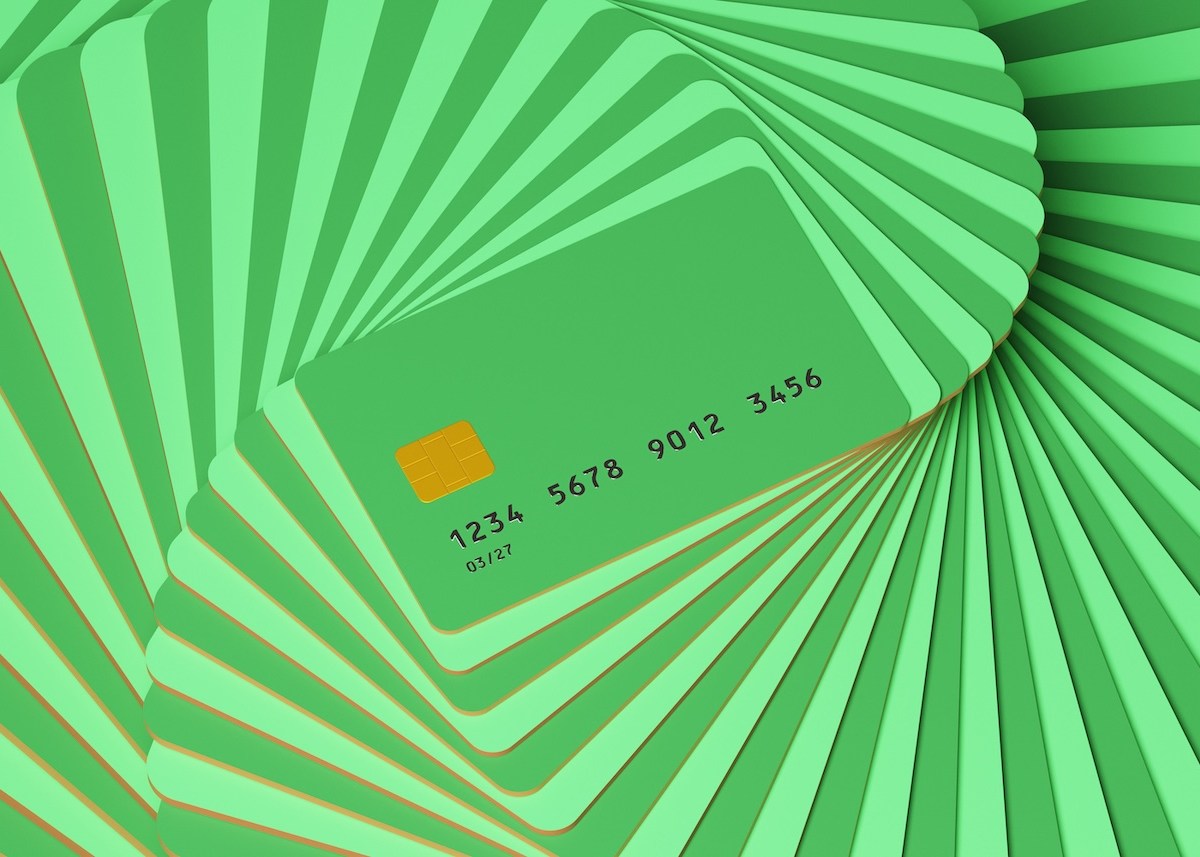 Abstraktes Bild von Kreditkarten, die in einem spiralförmigen Muster in hellen und dunklen Grüntönen immer größer werden.