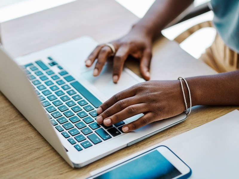 Afrikanische Geschäftsfrau recherchiert und plant allein in ihrem Büro an einem Laptop.