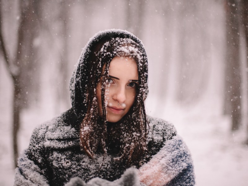 Wintereinbruch Frau im Schnee mit Mütze Auswirkungen Psyche