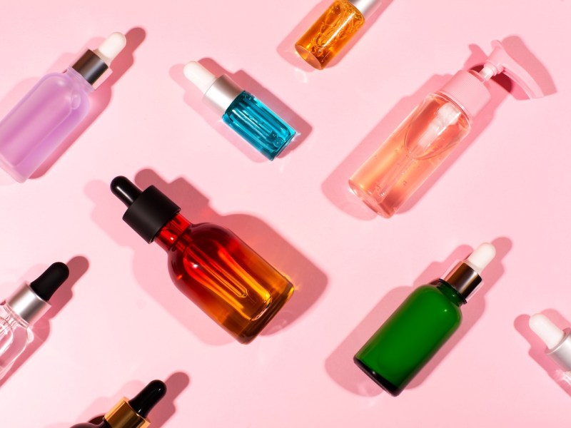 Kosmetikprodukte mit Lidschatten auf rosa Hintergrund.