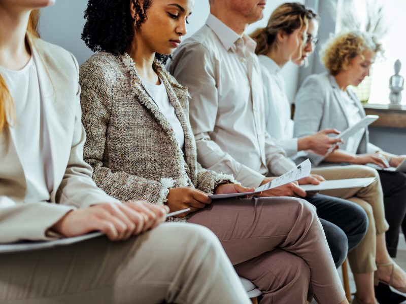 Eine Gruppe junger Menschen warten auf ein Vorstellungsgespräch.