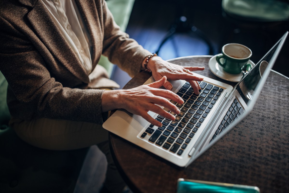Eine Frau arbeitet in einem Café an ihrem Laptop.